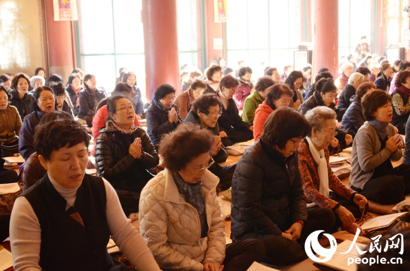 首爾曹溪寺大雄殿內聚滿了前來為考生祈願的家長。成碩攝