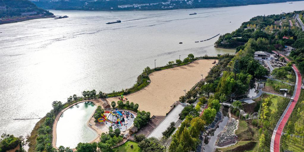 Moradores passam tempo de lazer em calçada ao longo de rio no distrito de Yunyang, em Chongqing