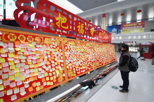 1月28日，旅客在“春运寄语墙”前驻足观看。新华社记者 张楠 摄