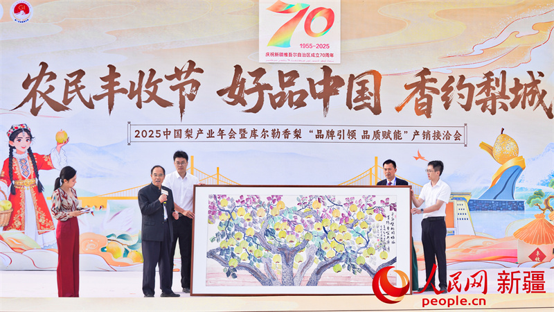雙方簽署戰略合作協議後,山東萊陽梨産業協會向新疆巴州庫爾勒香梨協會贈送畫作。人民網 李欣洋攝 雙方簽署戰略合作協議後,山東萊陽梨産業協會向新疆巴州庫爾勒香梨協會贈送畫作。人民網 李欣洋攝